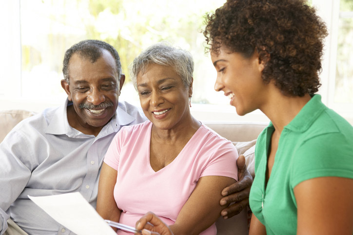 A skilled nursing facility worker at Booker T. Washington in Shreveport, LA reviews a financial document with a senior couple