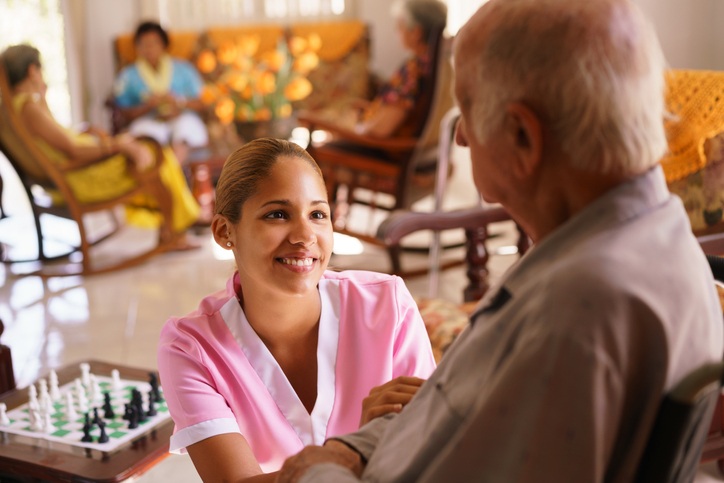 A nurse speaks with an elderly man, highlighting care facility at Booker T. Washington skilled nursing center in Shreveport, LA