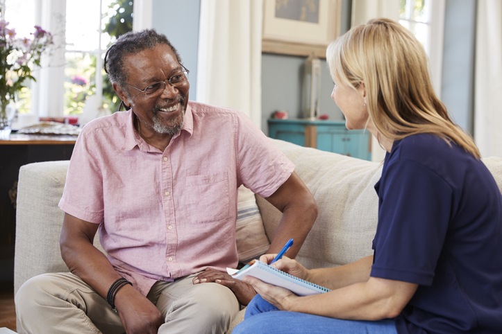 Woman converses with an older man on a couch, highlighting skilled nursing options in Shreveport, LA